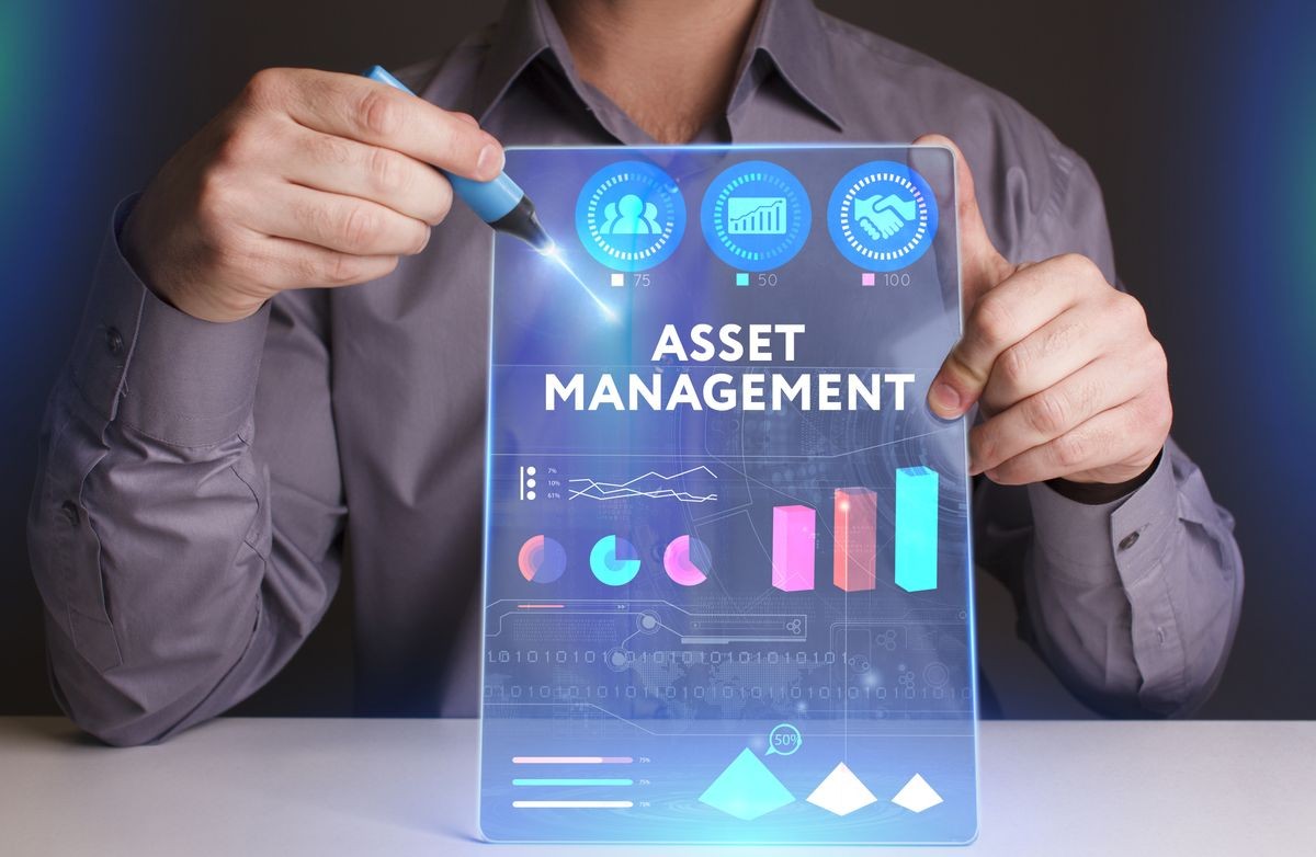 Business, Technology, Internet and network concept. Young businessman working on a virtual screen of the future and sees the inscription: Asset management